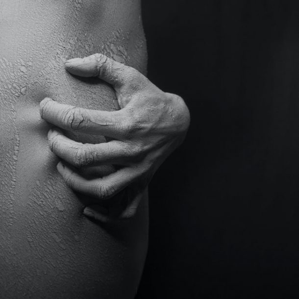close up photo of a person s hand scratching on his flaky skin in black and white